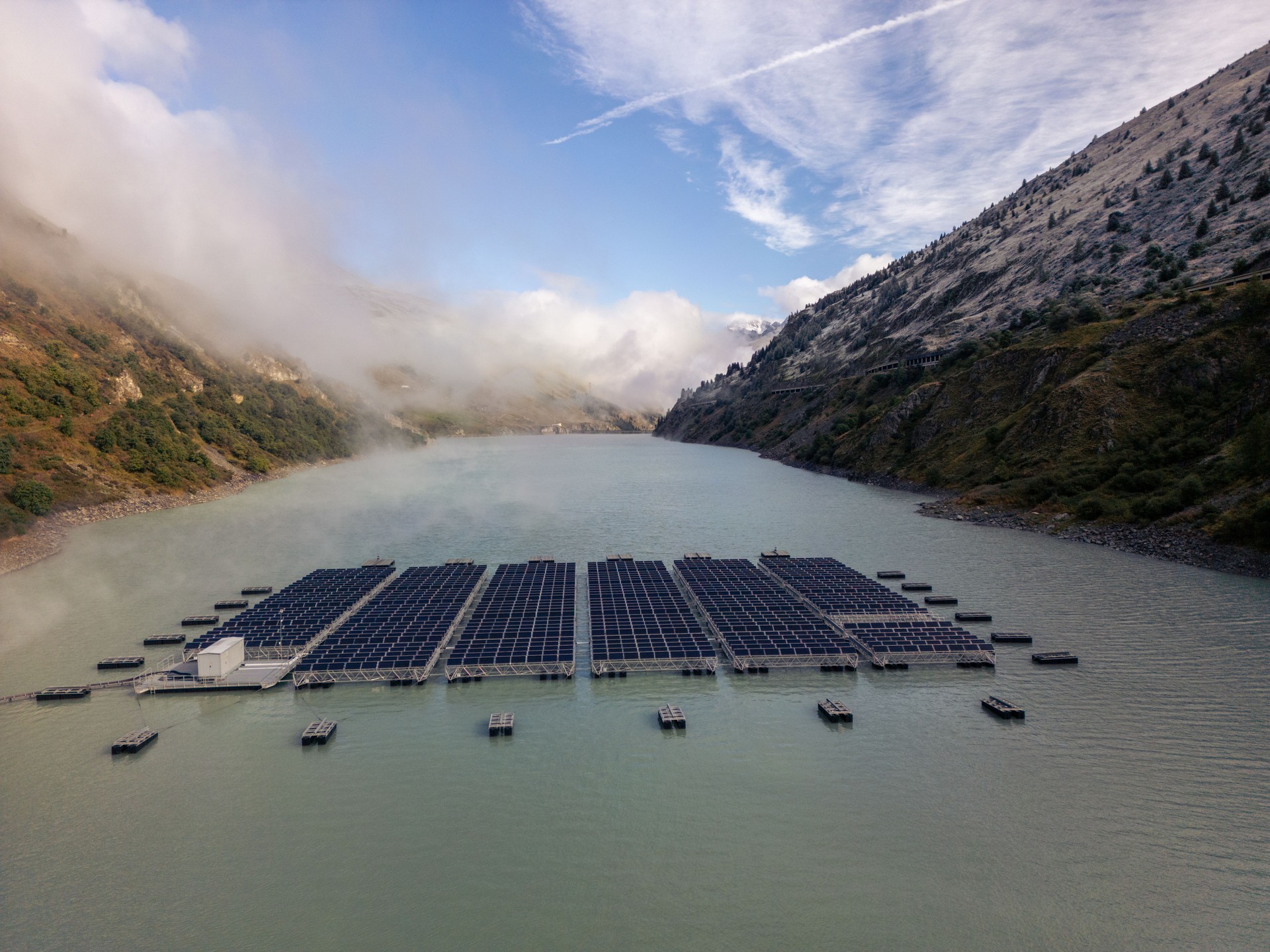 Floating Solar Panels with Foggy Mountainous Backdrop
