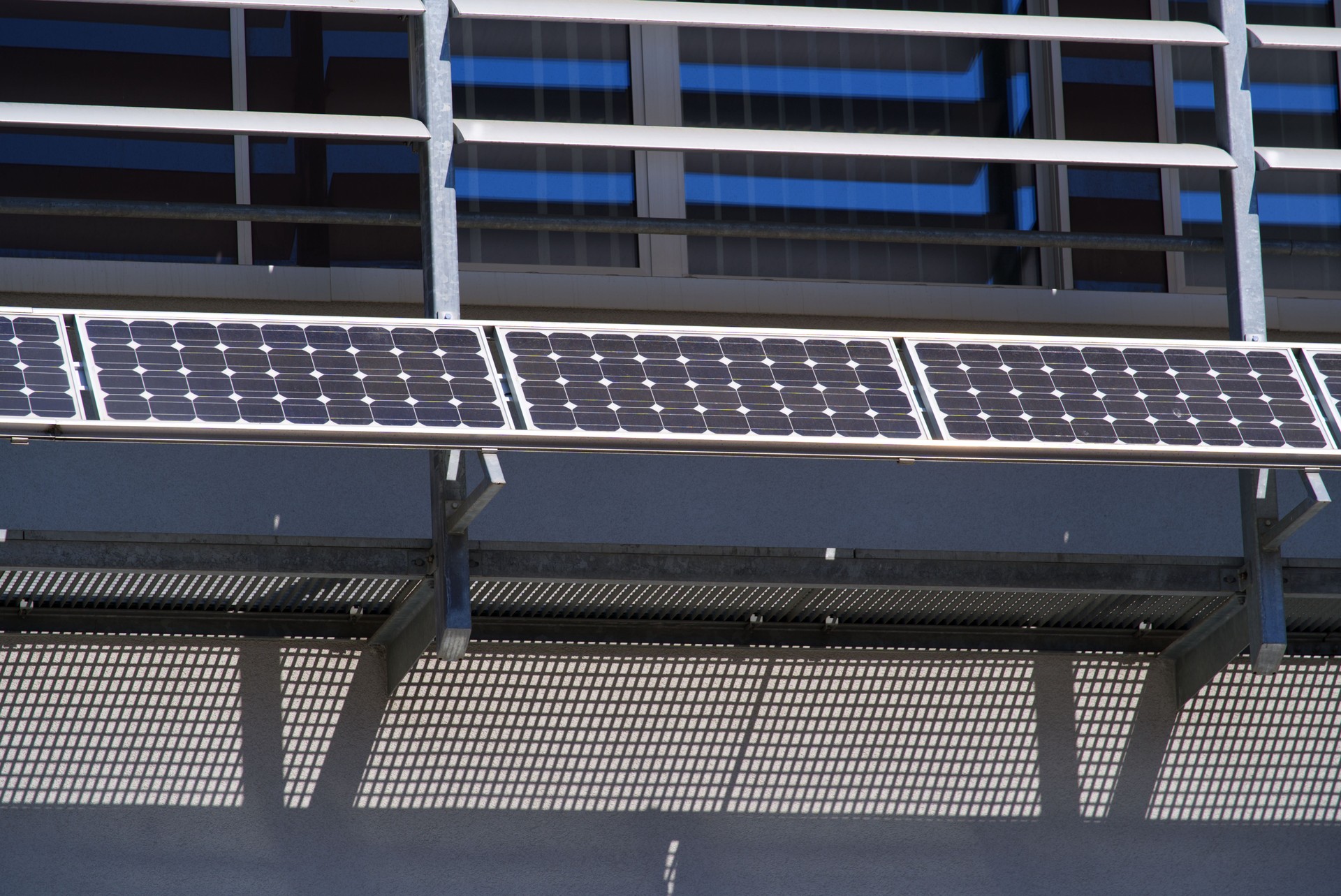 Solar panels of photo-voltaic module at facade of office building at the old town of Sion on a sunny spring day.